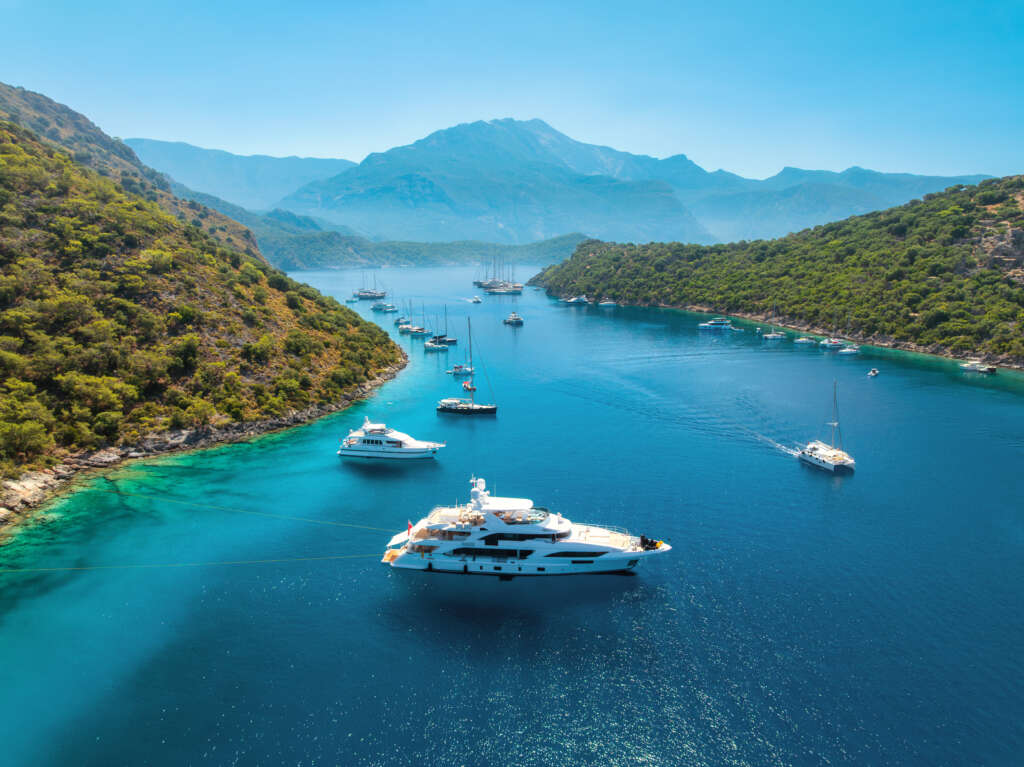 aerial view of yachts and boats on the sea at sunset in summer